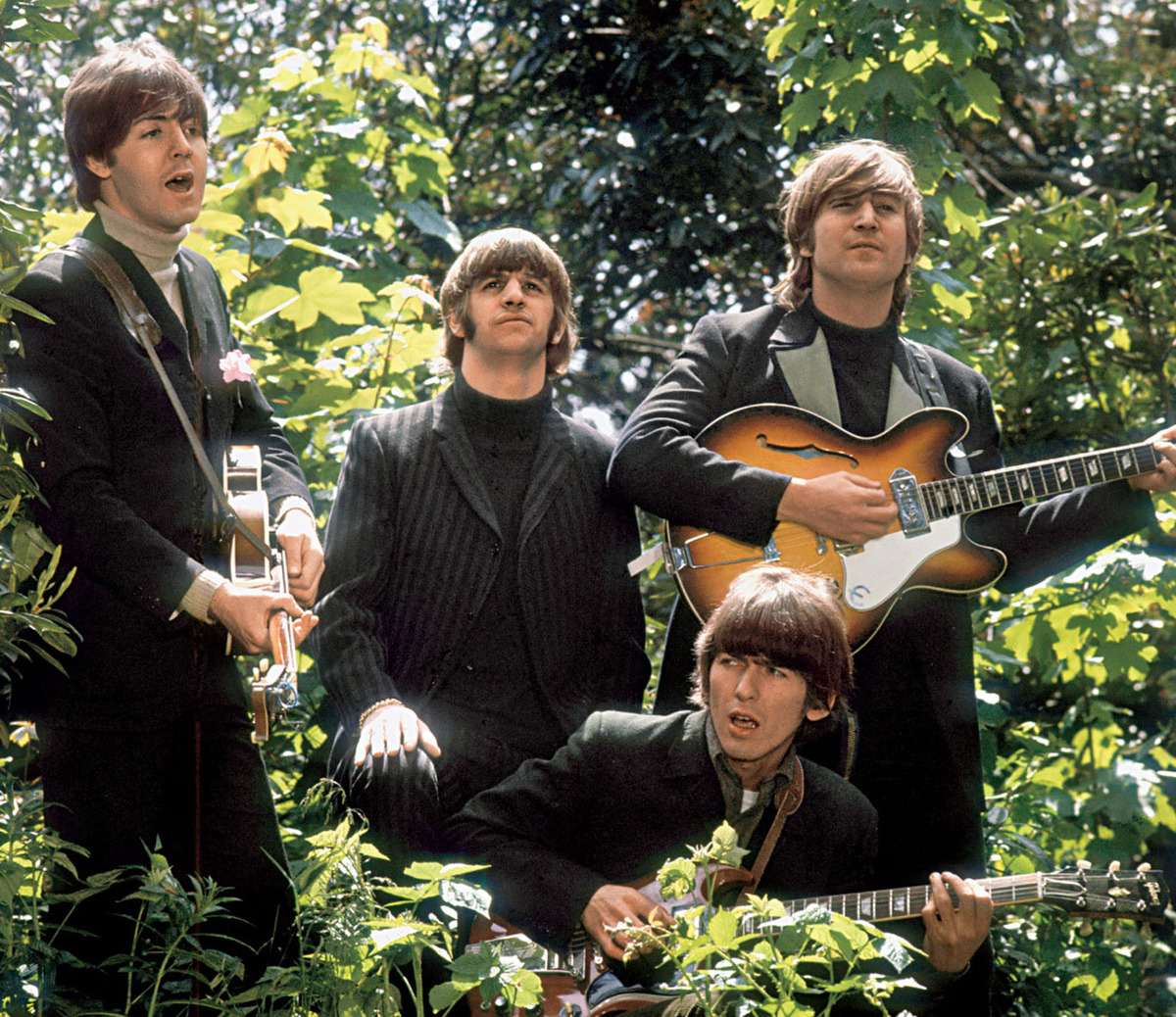 The Beatles walk and sing as they are filmed during a promotional video for their song Rain, in a garden outside Chiswick House